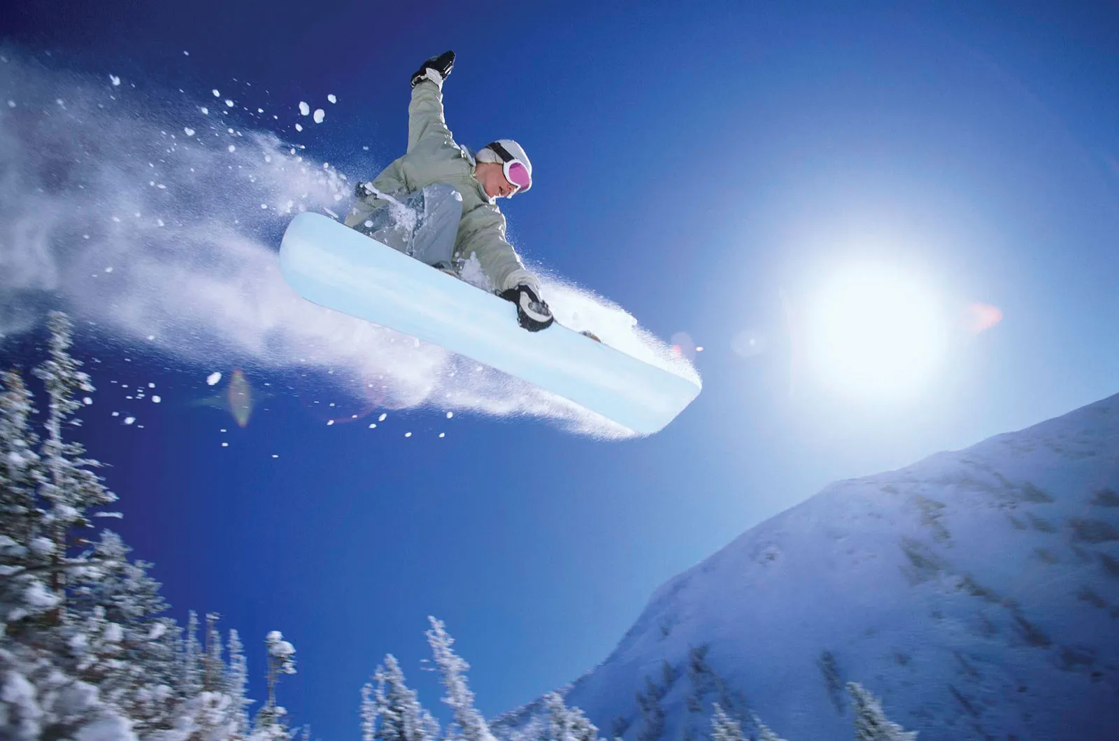A snowboarder hitting a sick slope.